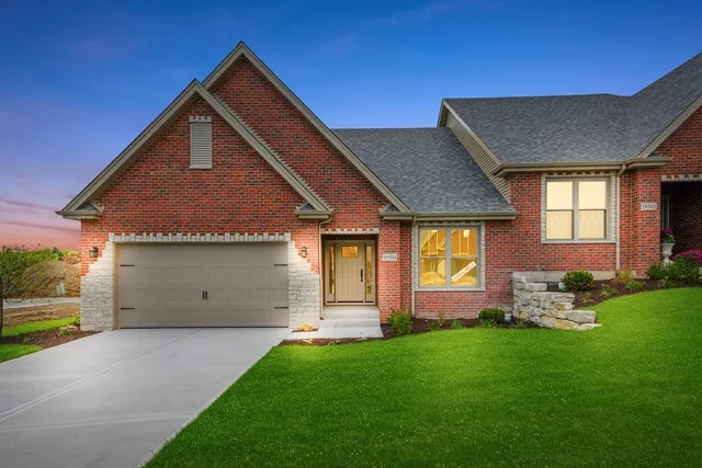 a front view of a house with a garden and yard