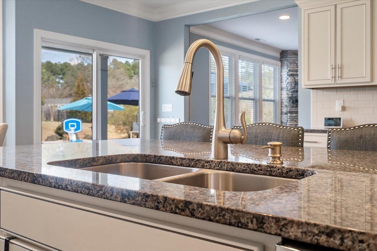 7399 Albemarle Drive Denver, NC 28037 - Photo 12 of 48 a kitchen with a granite countertop sink and natural light