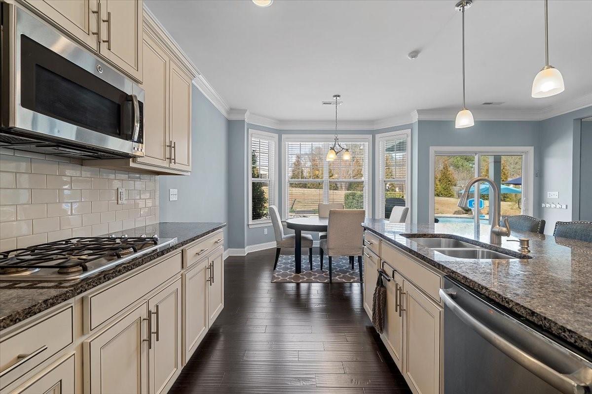 7399 Albemarle Drive Denver, NC 28037 - Photo 13 of 48 a kitchen with stainless steel appliances a kitchen island hardwood floor sink stove dining table and chairs