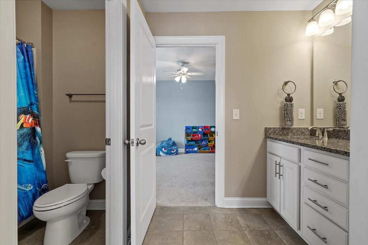 7399 Albemarle Drive Denver, NC 28037 - Photo 34 of 48 a bathroom with a granite countertop toilet a sink and a mirror