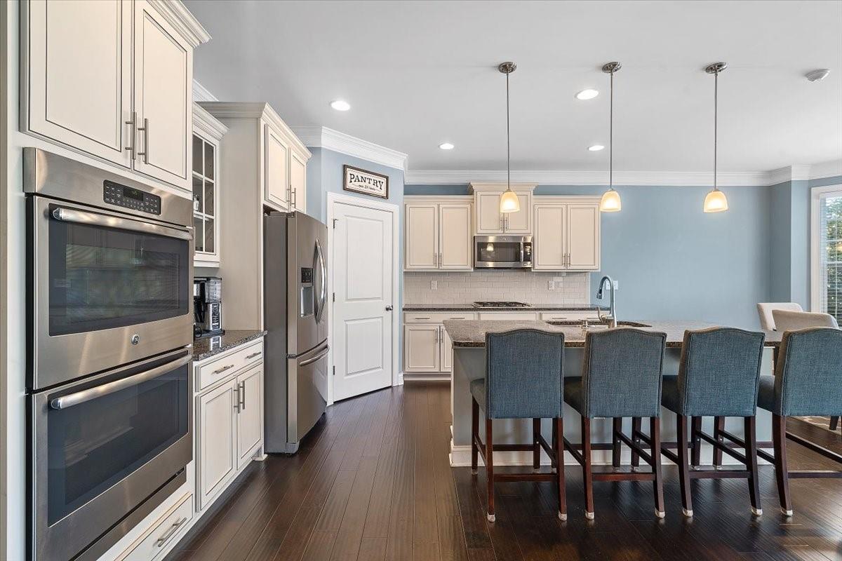 7399 Albemarle Drive Denver, NC 28037 - Photo 8 of 48 a kitchen with stainless steel appliances granite countertop a refrigerator a stove a sink a dining table and chairs with wooden floor