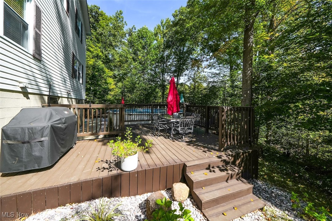 17808 Nash Road Middlefield, OH 44062 - Photo 11 of 43 Wooden deck with outdoor dining area, area for grilling, and view of wooded area