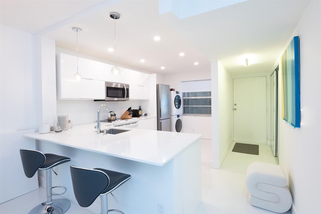 3581 South Ocean Boulevard, Unit 2B Palm Beach, FL 33480 - Photo 18 of 41 a kitchen with stainless steel appliances kitchen island granite countertop a sink and chairs