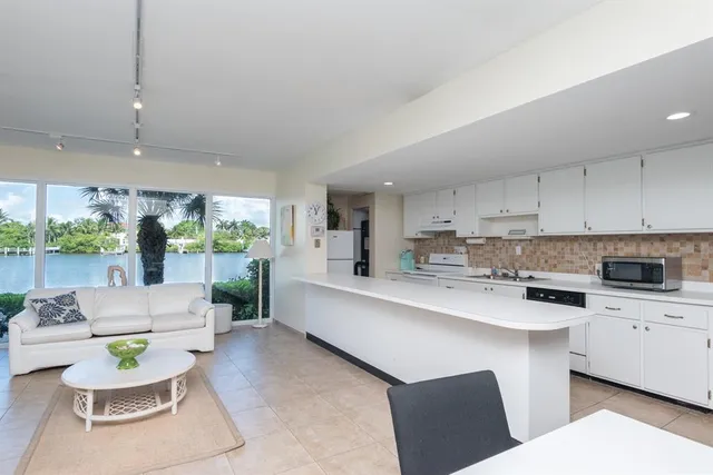 a large white kitchen with a white table and chairs