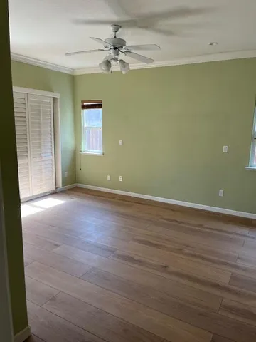an empty room with wooden floor and windows