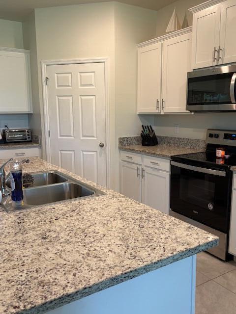 571 Old Country Rd S East Palm Bay, FL 32909 - Photo 7 of 37 a kitchen with stainless steel appliances granite countertop a sink stove and refrigerator