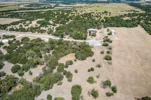 a view of a dry yard with wooden fence