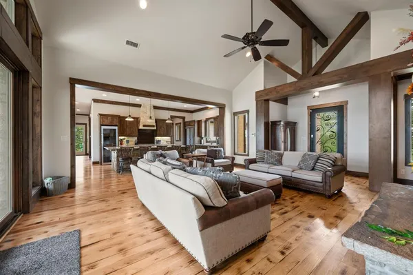 a living room with furniture ceiling fan and a wooden floor