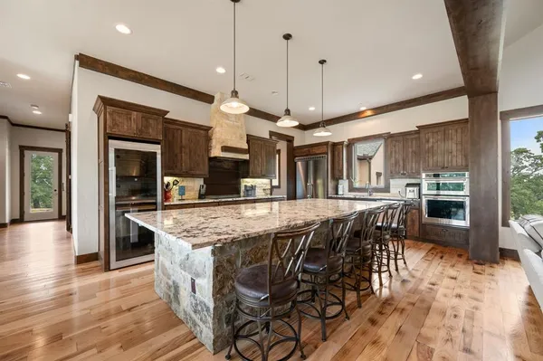 a kitchen with stainless steel appliances granite countertop a kitchen island a stove a table and chairs