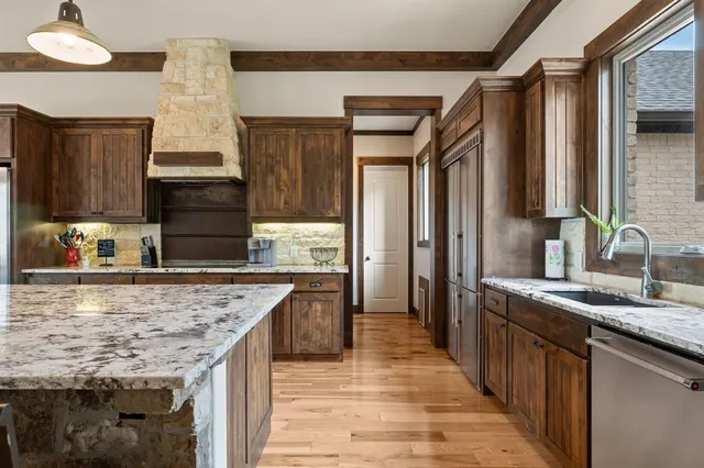 a kitchen with kitchen island granite countertop a sink stove and refrigerator