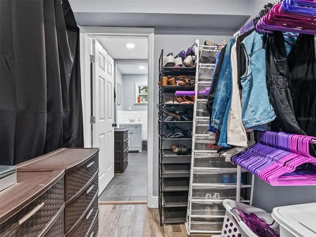 a view of walk in closet with clothes and shoes