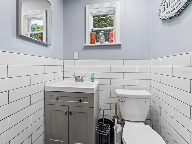 a bathroom with a toilet a sink and mirror