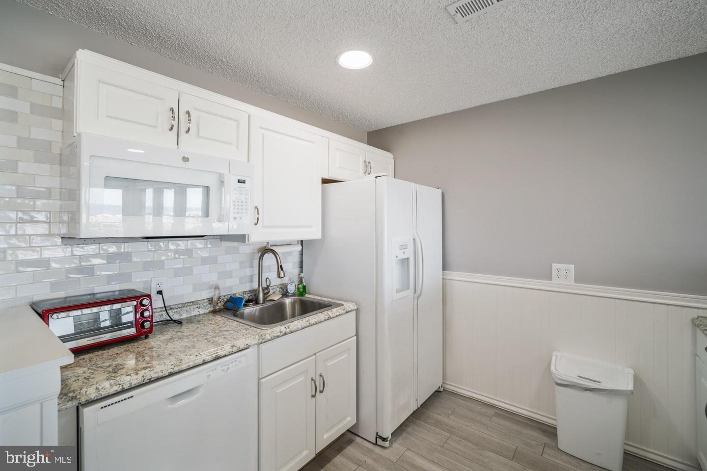 1001 Ocean Avenue, Unit 1017 Ship Bottom, NJ 08008 - Photo 26 of 31 a kitchen with a sink a toilet and cabinets
