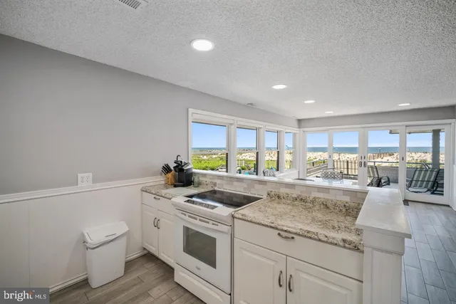 a view of a kitchen with granite countertop a sink and a stove