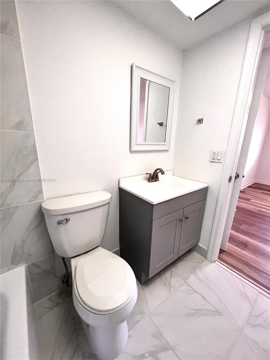 22795 Southwest 66th Avenue, Unit 206 Boca Raton, FL 33428 - Photo 23 of 29 a bathroom with a toilet sink and mirror