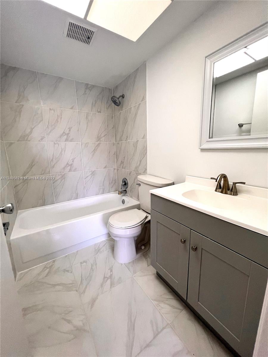 22795 Southwest 66th Avenue, Unit 206 Boca Raton, FL 33428 - Photo 24 of 29 a bathroom with a sink a toilet and a bathtub