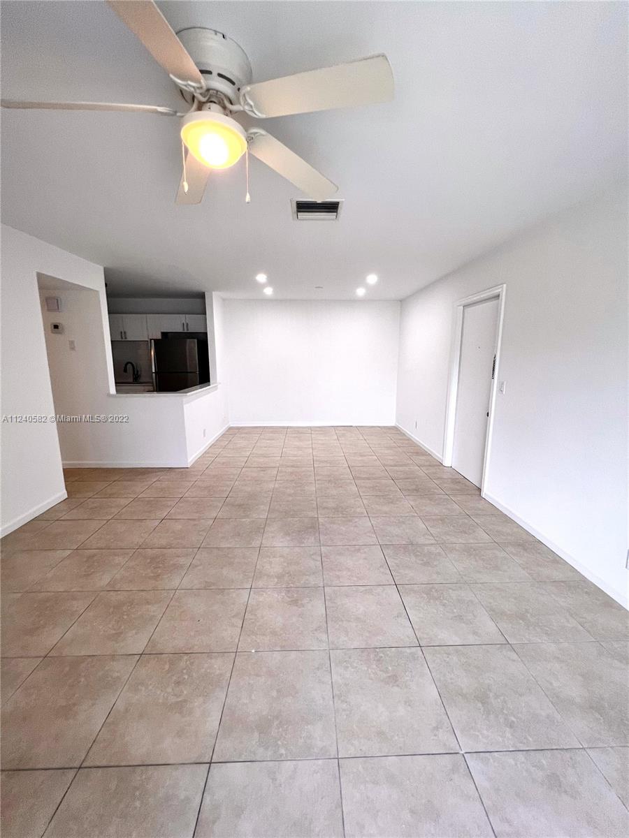 22795 Southwest 66th Avenue, Unit 206 Boca Raton, FL 33428 - Photo 3 of 29 a view of an empty room with wooden floor and windows