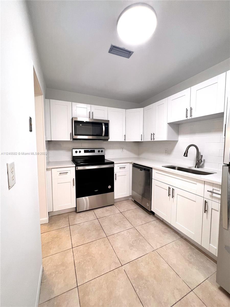22795 Southwest 66th Avenue, Unit 206 Boca Raton, FL 33428 - Photo 6 of 29 a kitchen with a stove sink and cabinets