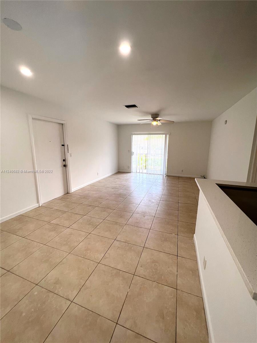 22795 Southwest 66th Avenue, Unit 206 Boca Raton, FL 33428 - Photo 7 of 29 a large white kitchen with a sink and cabinets