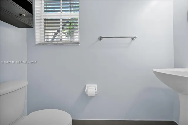 a bathroom with a toilet a sink and mirror