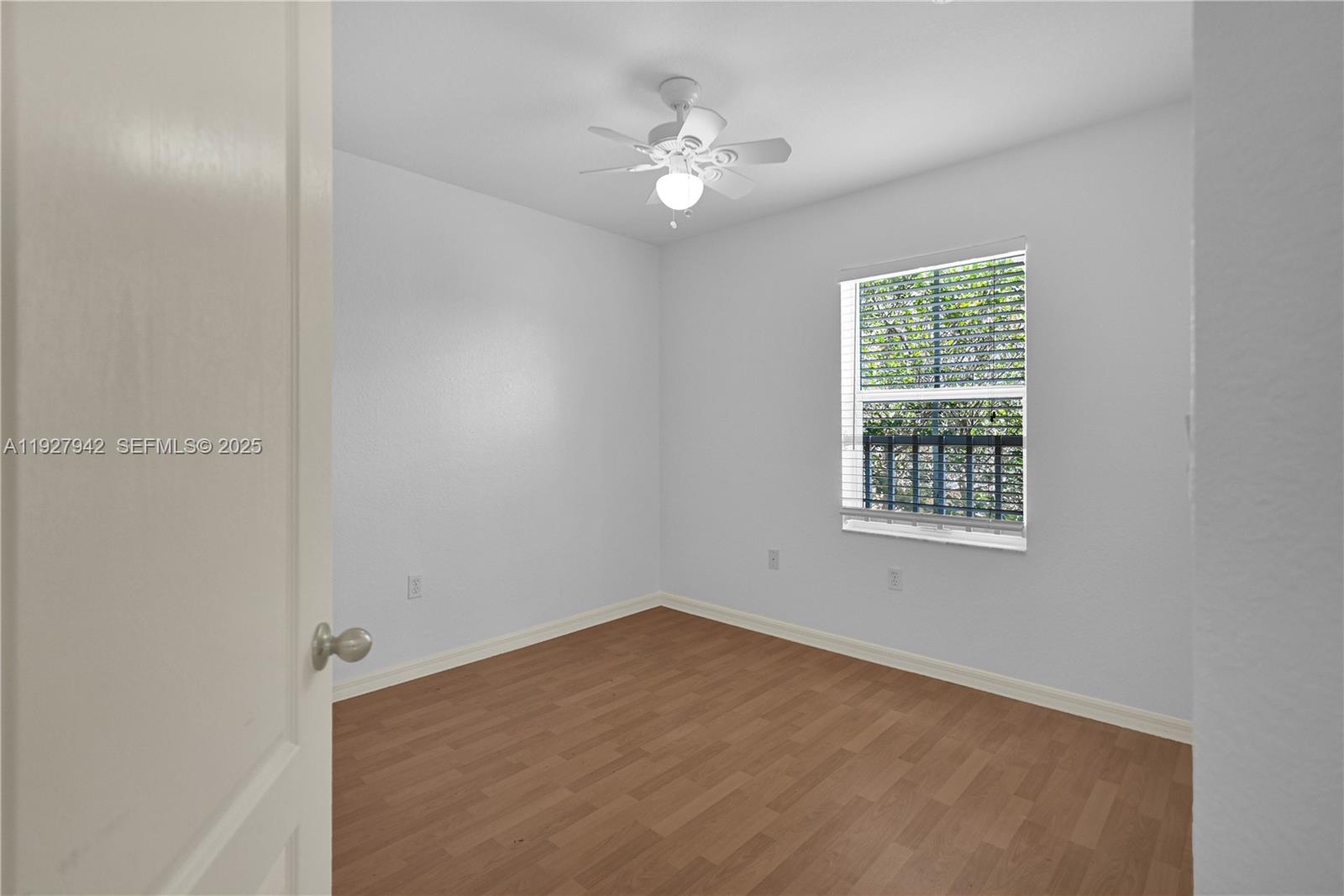 12832 Southwest 30th Street, Unit 118 Miramar, FL 33027 - Photo 17 of 29 an empty room with a chandelier fan and windows