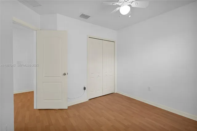 an empty room with a fan and a chandelier fan