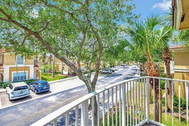 a view of a house with a yard and large trees