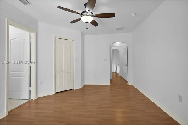 wooden floor in an empty room with a chandelier