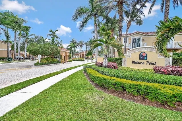 a front view of multi story residential apartment building with yard and green space