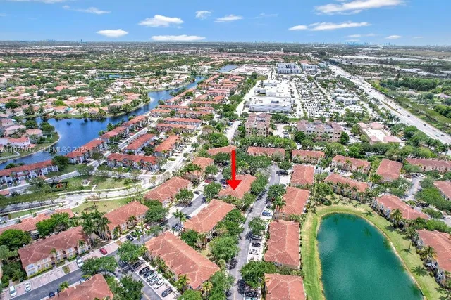 an aerial view of residential houses with outdoor space and trees