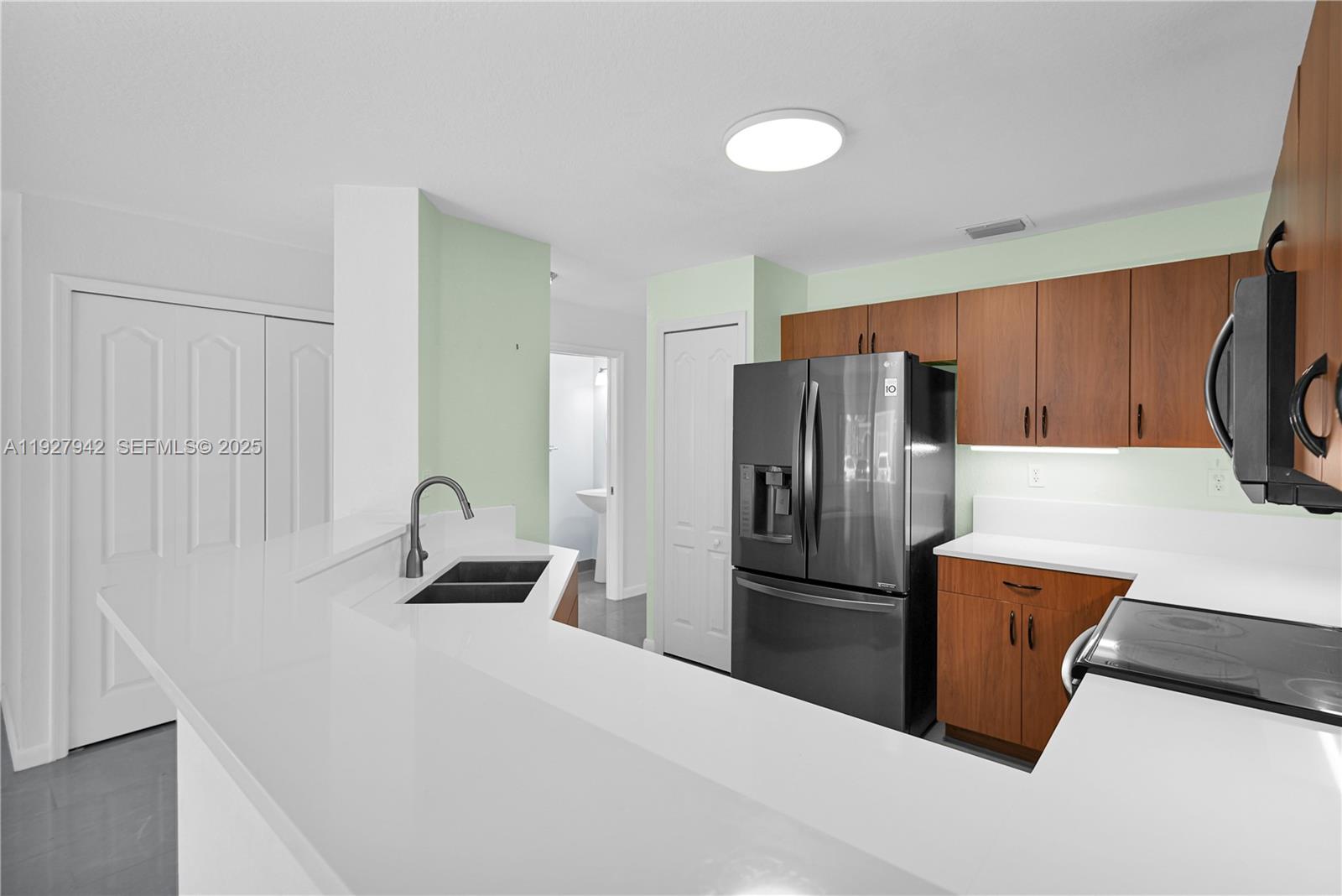 12832 Southwest 30th Street, Unit 118 Miramar, FL 33027 - Photo 10 of 29 a kitchen with stainless steel appliances a refrigerator and a stove