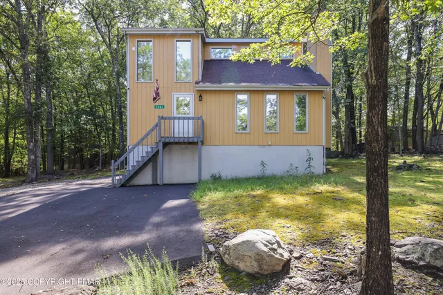 a view of a house with backyard and sitting area