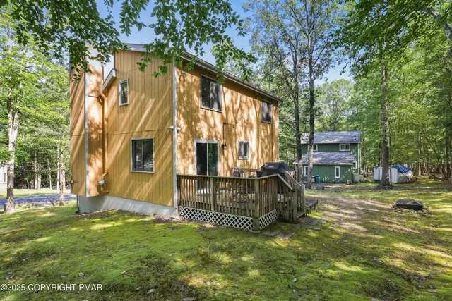a view of backyard with deck and garden