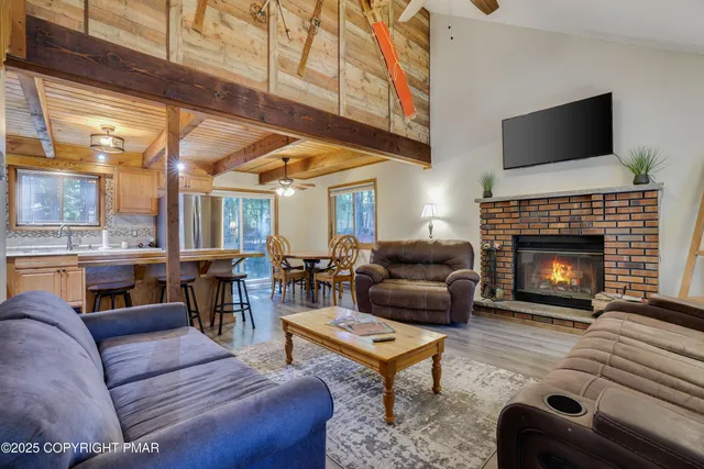 a living room with furniture a fireplace and a flat screen tv