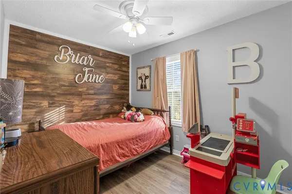 a bedroom with a bed and a bookshelf with wooden floor