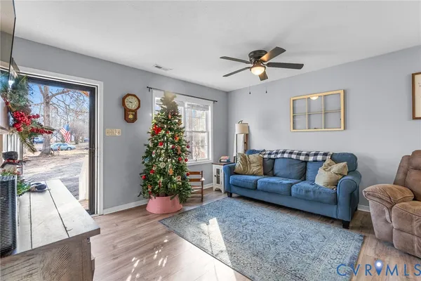 a living room with furniture flower pot and wooden floor