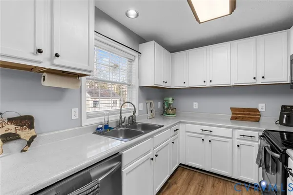 a kitchen with stainless steel appliances granite countertop white cabinets sink and dishwasher