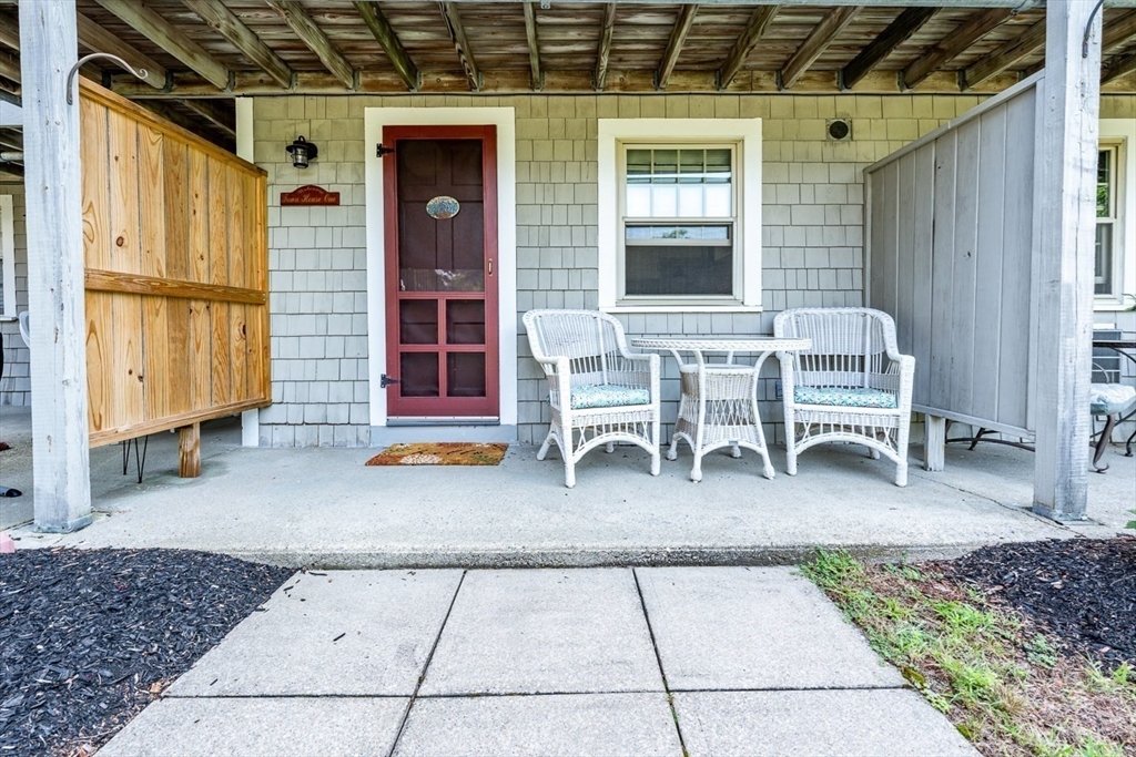 141 Main Street, Unit TH1 Dennis, MA 02660 - Photo 18 of 27 a backyard view of a house with barbeque oven table and chairs