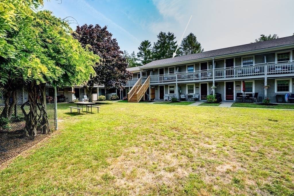 141 Main Street, Unit TH1 Dennis, MA 02660 - Photo 20 of 27 a view of a swimming pool and trees in the background