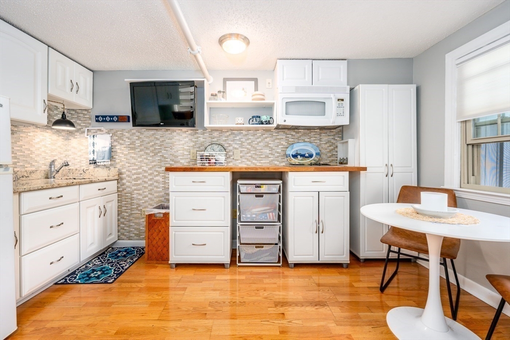 141 Main Street, Unit TH1 Dennis, MA 02660 - Photo 6 of 27 a kitchen with stainless steel appliances a stove a sink cabinets and a refrigerator
