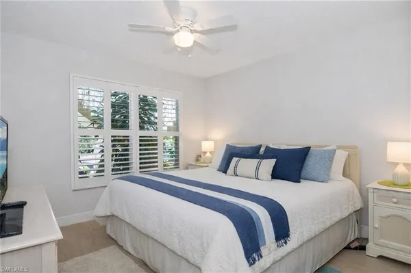 a bedroom with a large bed and a flat tv screen on dresser