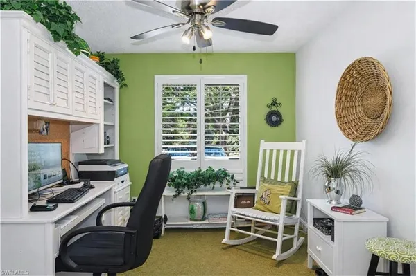a view of a workspace with furniture and a window