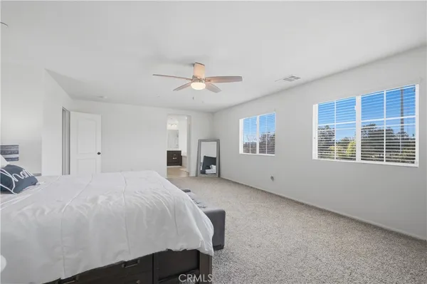a spacious bedroom with a bed and a chandelier