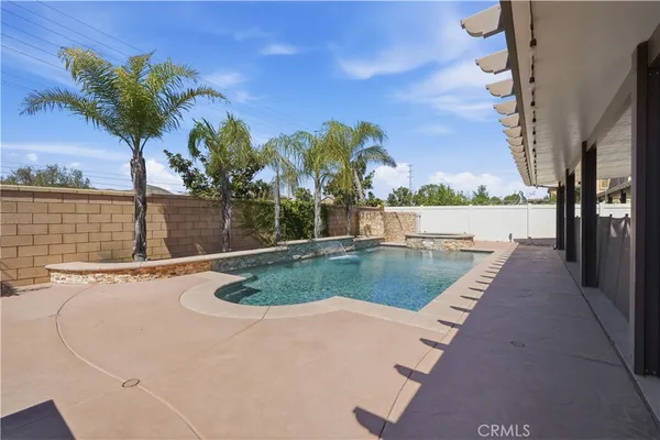 a view of a swimming pool with a patio and a yard