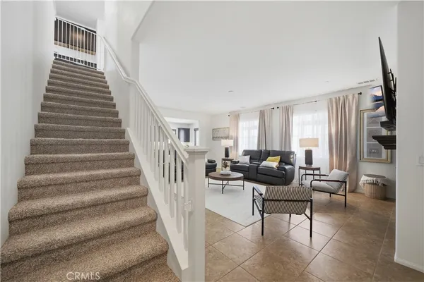 a living room with furniture and stairs