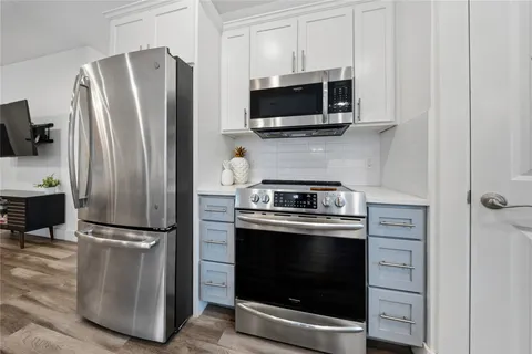 a kitchen with stainless steel appliances a refrigerator stove and microwave