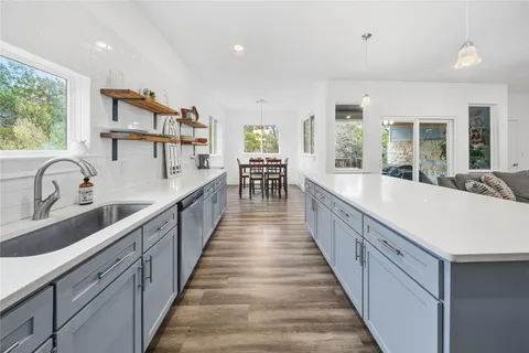 a large white kitchen with lots of counter space and windows