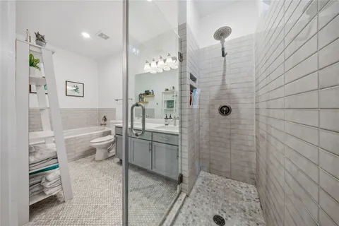 a bathroom with a sink a toilet and shower