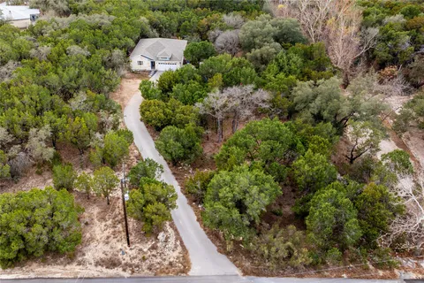 an aerial view of a house with a yard and large tree