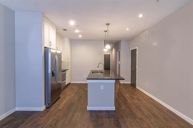 a kitchen with granite countertop a refrigerator and a sink